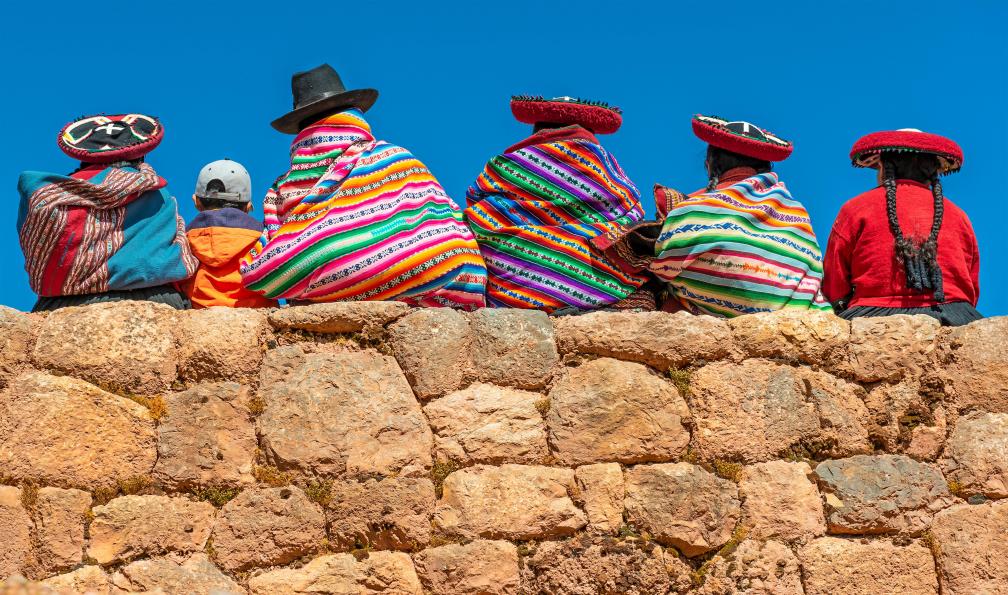 SL-Photography - Adobe stock - Habitants de Quechua en vêtements traditionnels assis sur un ancien mur inca dans le site archéologique de Chinchero dans la région de la ville de Cusco, au Pérou voyages incontournables