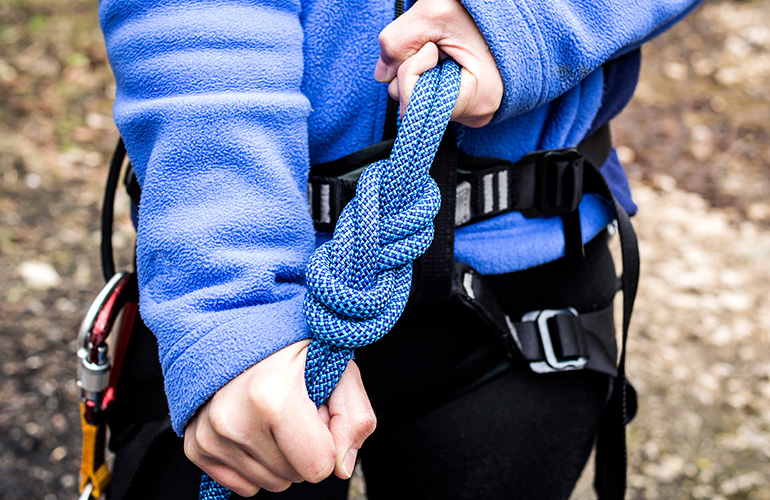 Femme faisant un noeud de huit pour se sécuriser en escalade