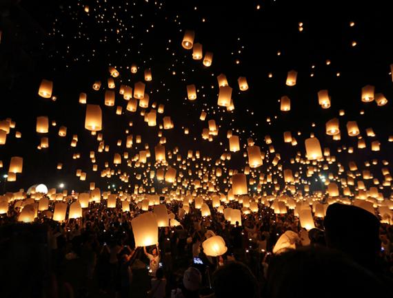 Lanternes s'envolant dans le ciel lors d'un festival en Thaïland.