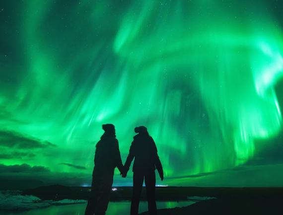 Couple regardant les aurores boréales en Islande.