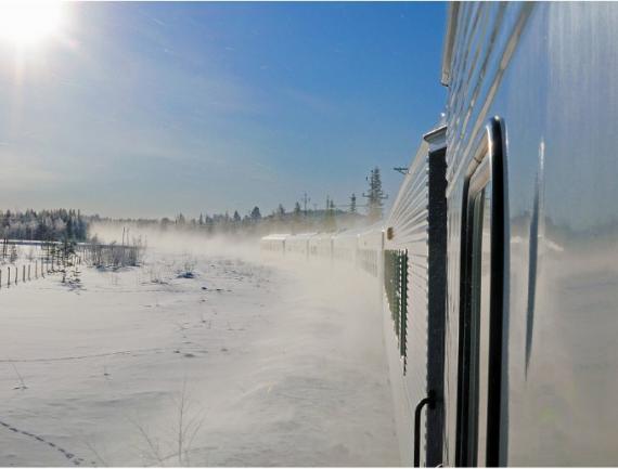 Un train suédois traverse des champs de neige étincelants au soleil, en Laponie
