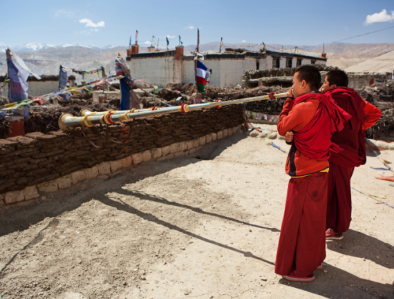 Jeunes Moines bouddhistes tibétains jouant de cornes sur le toit, LoManthang, Népal
