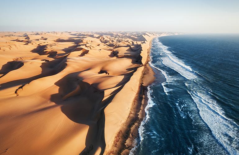 Dunes de sable se jettant dans l'Océan, Namibie, Afrique.