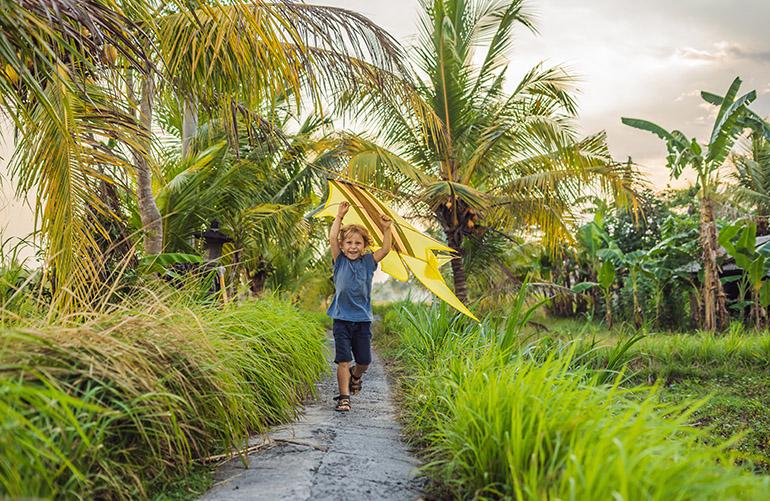 © galitskaya - Adobe Stock Enfant jouant avec un cerf-volant, Ubud, Bali, Indonésie.