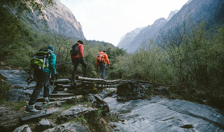 © yossarian6 - Adobe Stock Groupe de marcheurs traversant un pont au dessus d'une rivière.