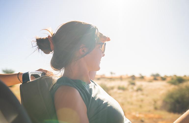 Femme qui cache son visage du soleil lors d'un safari, Namibie