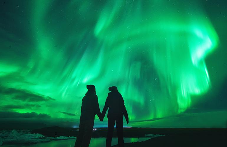 Couple regardant les aurores boréales en Islande.