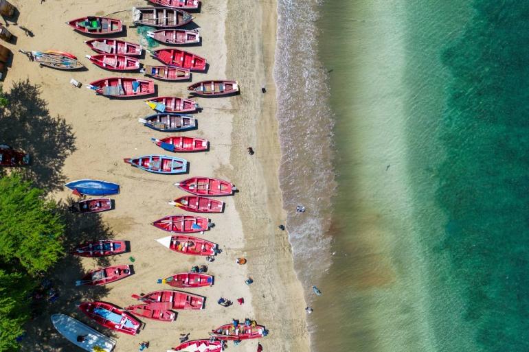 Vue aérienne de la plage de Tarrafal et ses bateaux de pêches en bois colorés, rangés sur le sable, Cap-Vert
