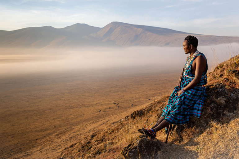 Masai assis au bord d’un des cratères de Ngorongoro, regardant l’horizon, Tanzanie